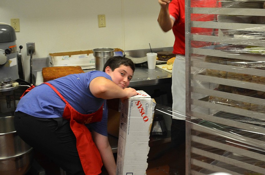 Josh Cohen has fun wrapping up trays of cut fruit