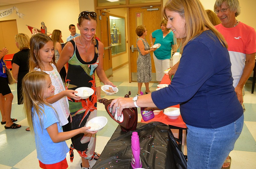 Jovie, Sunni and Kristina Schurr wait for their ice cream scoops delivered by Sue-Anne Danko.