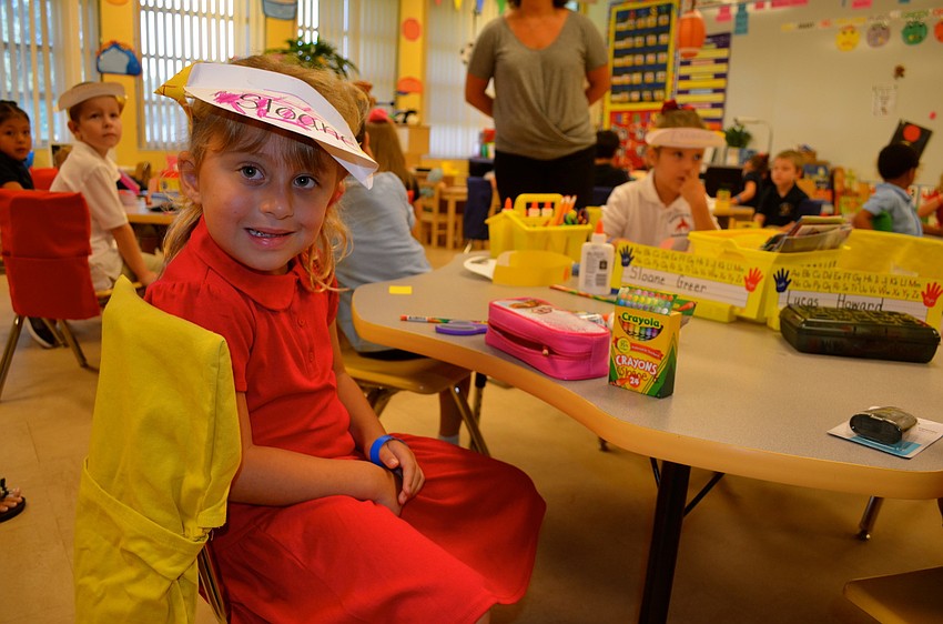 Sloane Greer shows off her first craft project â€” a paper hat.