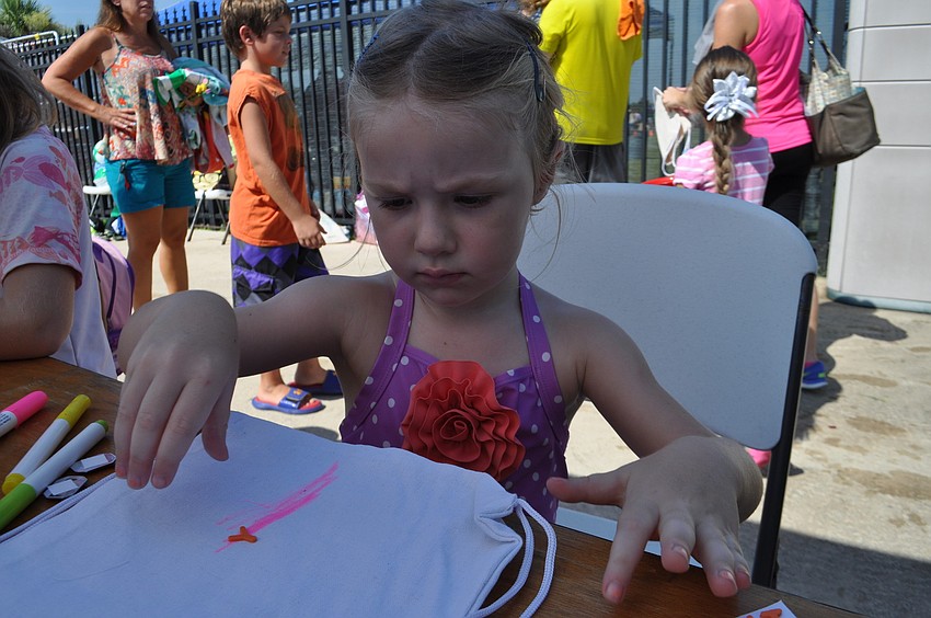 Hannah Fimple decorates a backpack.