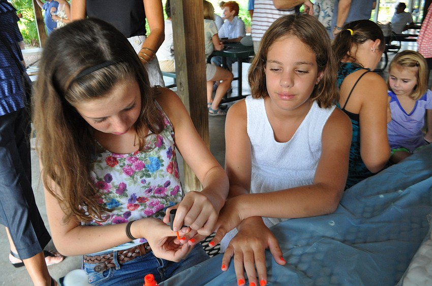 Nolan Middle School student Tayla Rosenthal paints the nails of Josie Liederman.