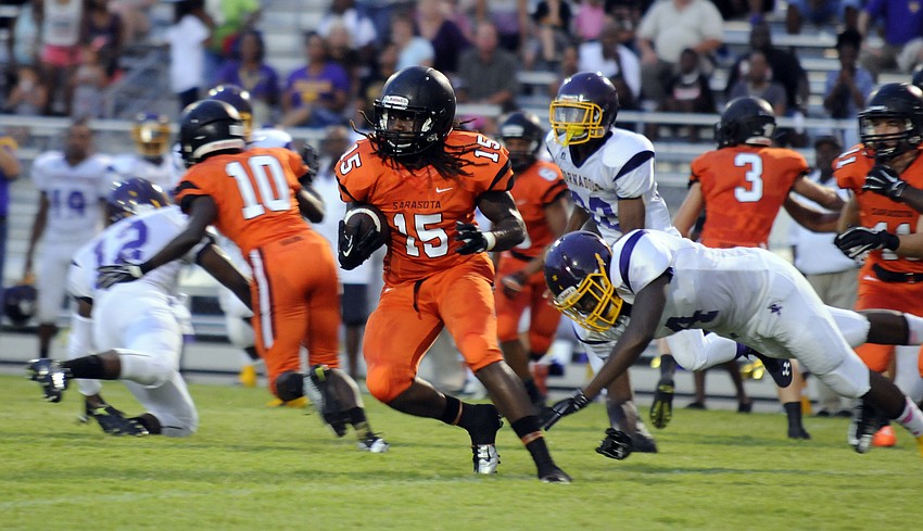 Sarasota senior Jacari Dunbar breaks past a Booker defender during a kickoff return in the second quarter.