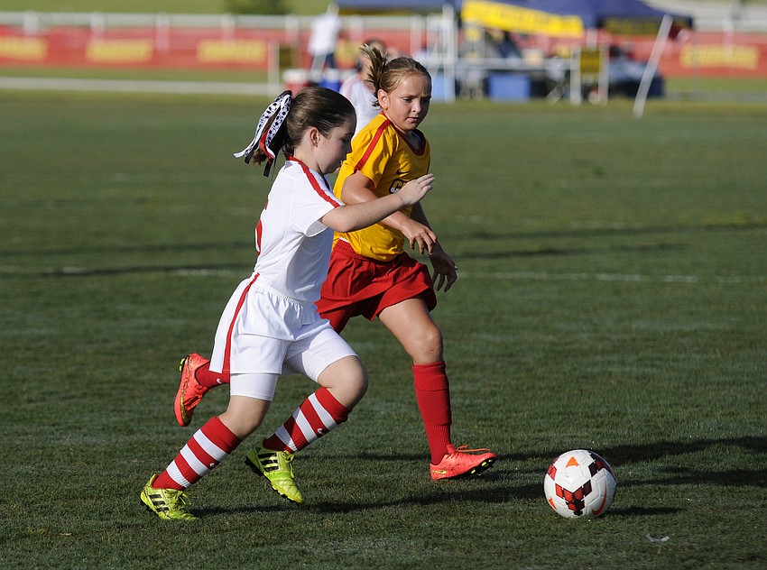 West Pasco Blackâ€™s Julie Michaels attempts to move the ball up the field past the Tampa Chargersâ€™ Tatum Moore.