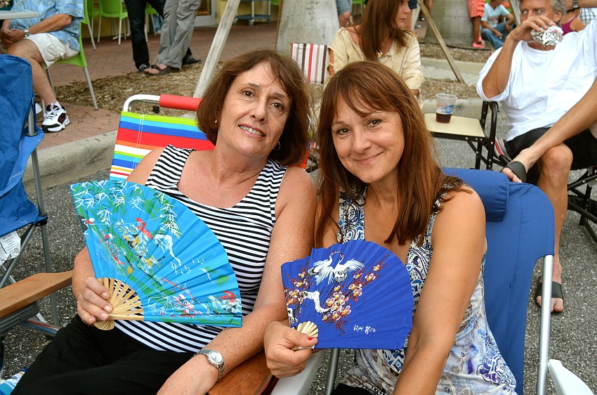Angela Johnson and Sally Larson try to cool down while outdoors.