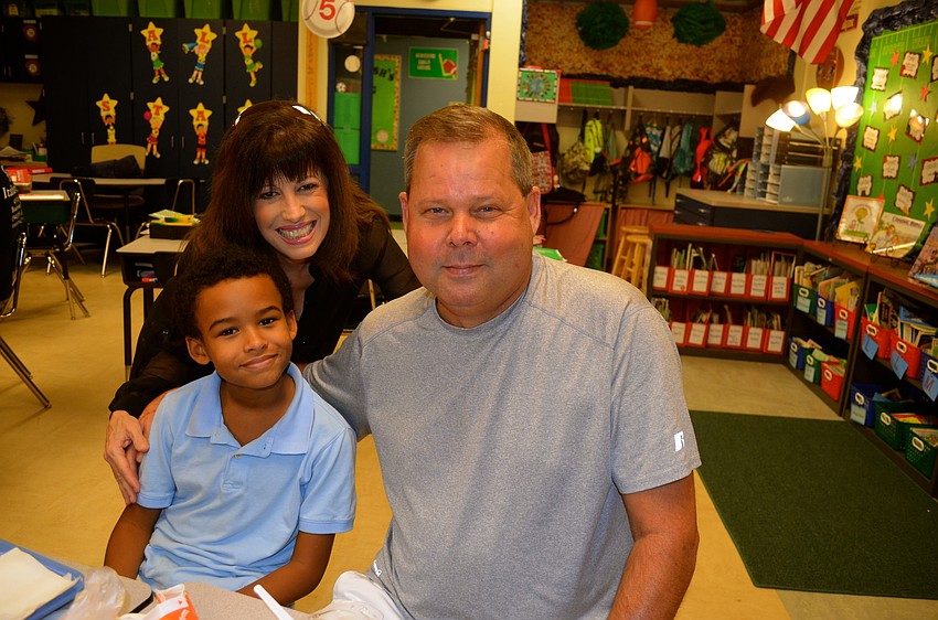 Margie Traylor and Chris Anthony spend time with Vincent Hutchinson in his classroom.