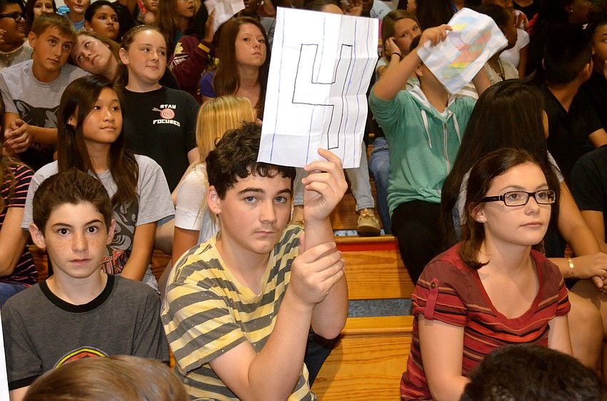 Zachary Booth holds up a sign in honor of Lou Gehrig's New York Yankees uniform number.