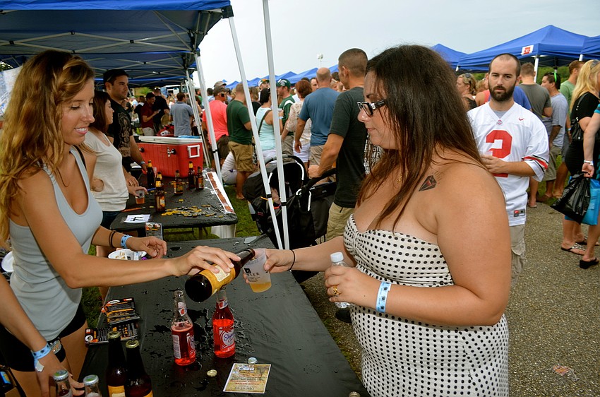 Theresa Schultz gives Erica Massey a sample of beer.