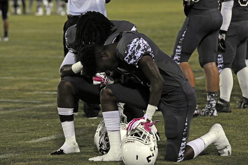 Braden River seniors Jimiah Albritton and Justin Ross huddle together in silent pray before the start of their district game versus Sarasota.