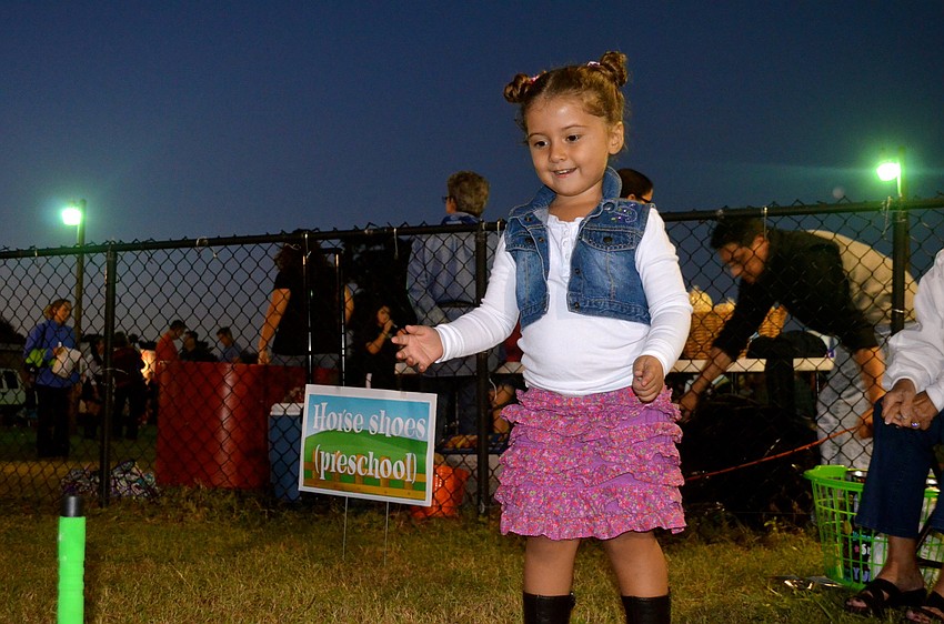 Emma Cordova plays a round of horseshoes while her parents cheer from the sidelines.