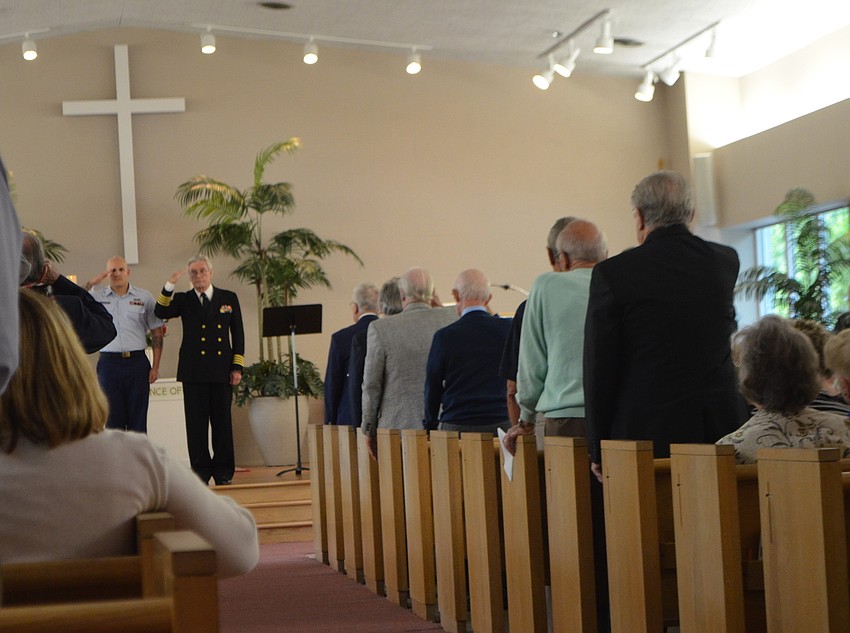 Erik Pierantoni and Rev. Dr. Vincent Carroll salute the veterans attending the service.
