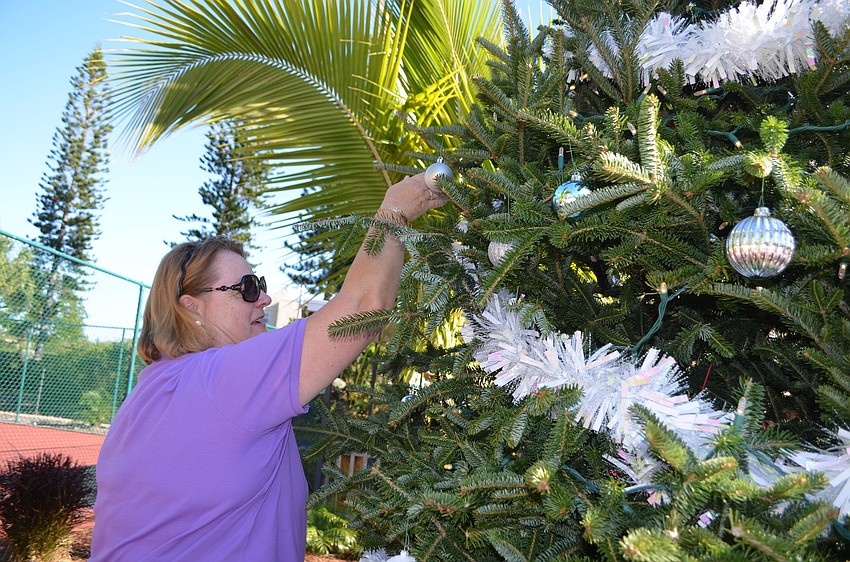 Marja Ivarsson puts and ornament on the tree.