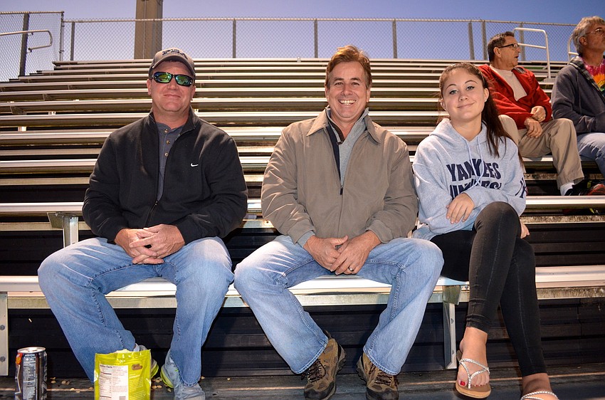 Bill Biggs, Randy Giddens and Emily Palkovich cheer from the sidelines.