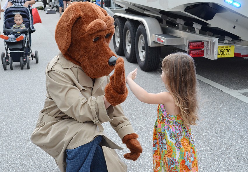 Kensley Lamb gives Scruff McGruff a high-five at the National Night Out Against Crime at Payne Park.