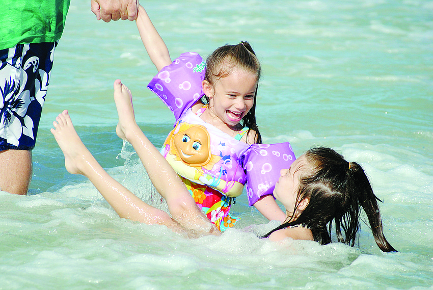 Sisters Juliet and Jessie Cantrell play in the water at the Hang Ten for Austim event at Siesta Key Beach.