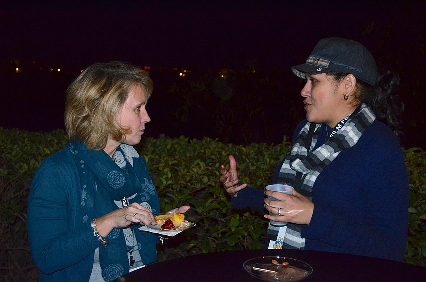 Robin Mullins and Kimberly North socialize over snacks and drinks.