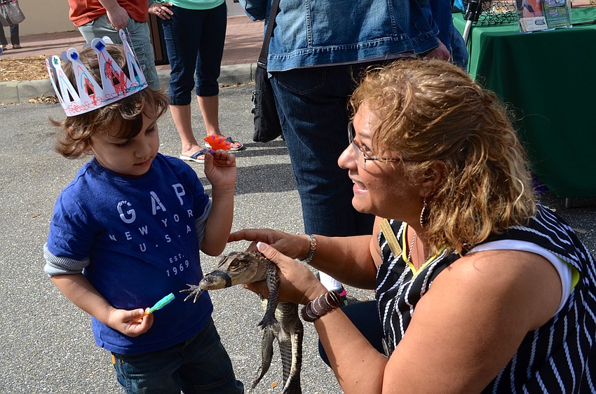 Okhan Ozturk learns about a baby alligator from Shirley Parrado.