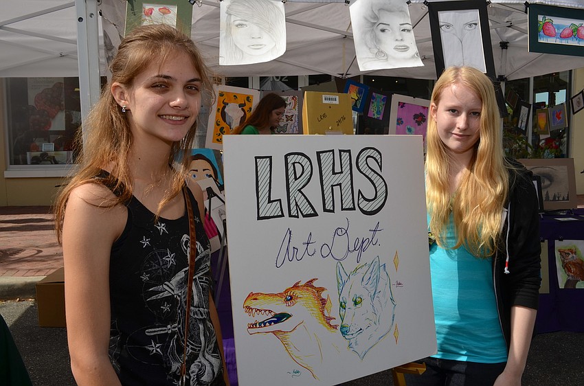 Kellie Fallon and Rowan Murry show off paintings they and their peers crafted.