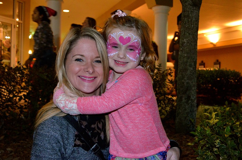 Julie Ruffing and her daughter, Avery, take advantage of the night's events, such as face painting.