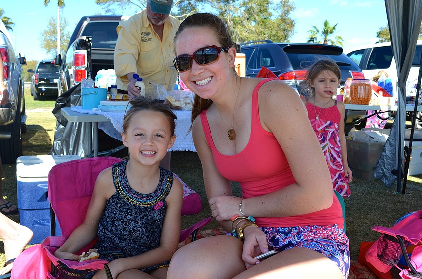 Brooke Rogers and Savannah Alario watch the polo match from the shade of their tent.