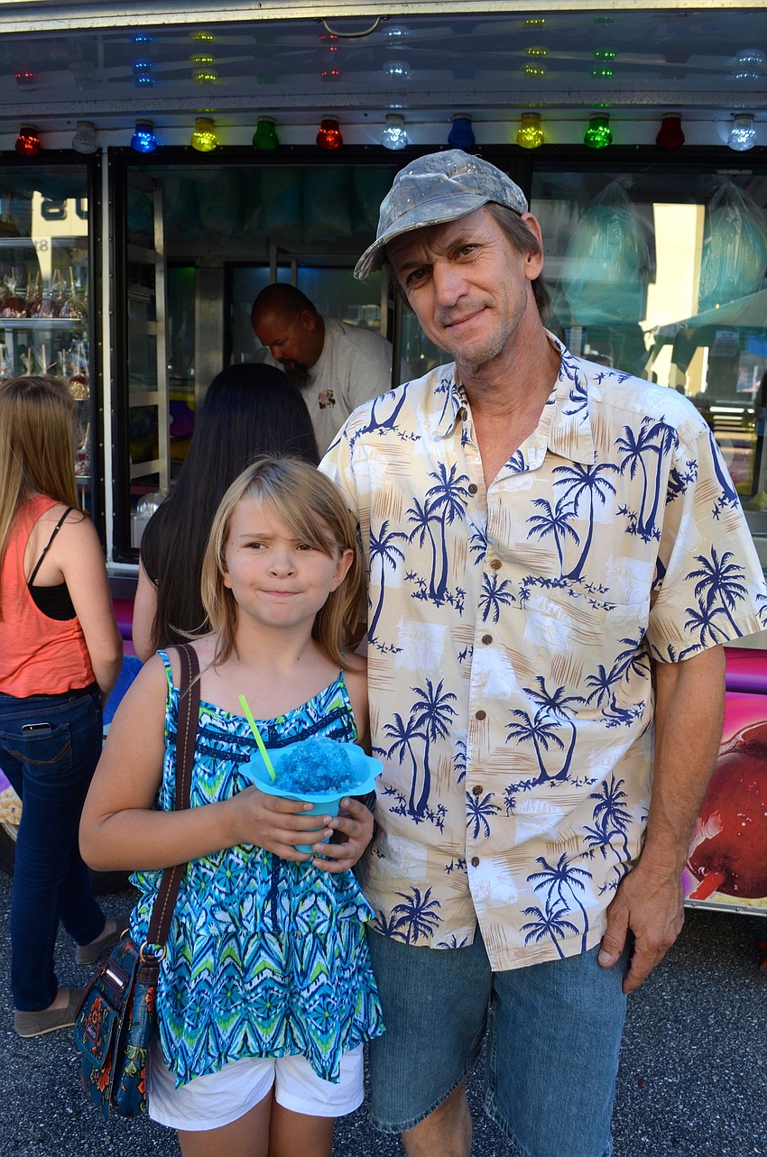 Caelyn Curry enjoys a frozen treat beside her father, Caleb.