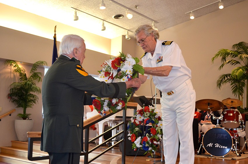John Casey gives a memorial wreath to the Rev. Vincent Carroll.
