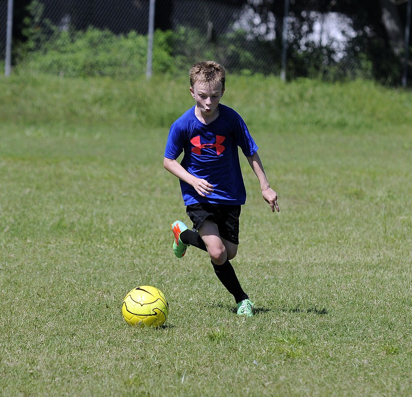 Twelve-year-old Owen Catlett charges toward the ball.