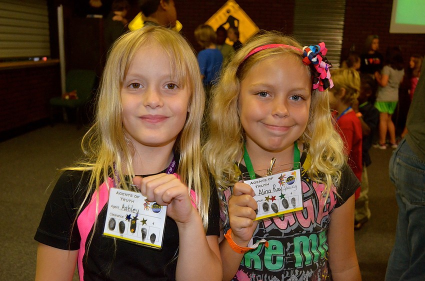 Ashley Dejarnette and Alina Young show their camper badges.