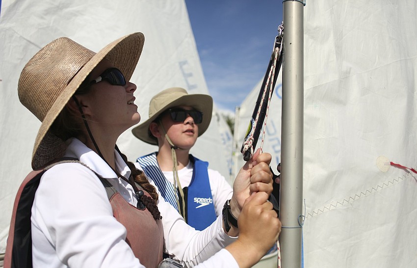Instructor Katie Freeley and camper Preston Kennedy, 11, secure the sails before taking to the water.