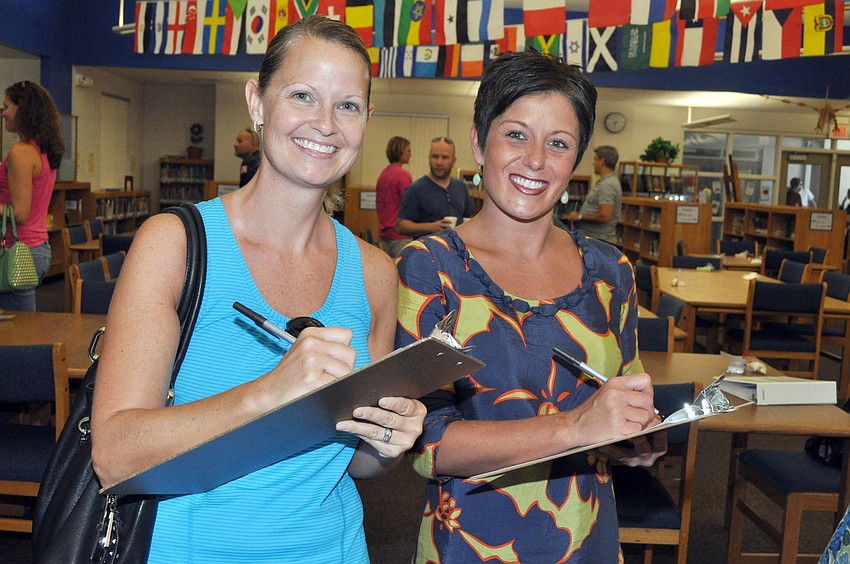 Merry Beth Raymond and Melissa Burns-Capaccione sign up for volunteering on the first day back to school at Phillippi Shores Elementary.