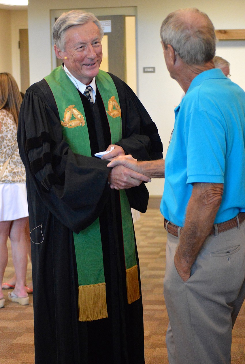 The Rev. Paul Eckel shakes hands with Christ Church of Longboat Key, Presbyterian congregation members. Eckel is the churchâ€™s interim part-time pastor, and he will continue to lead the church through November.
