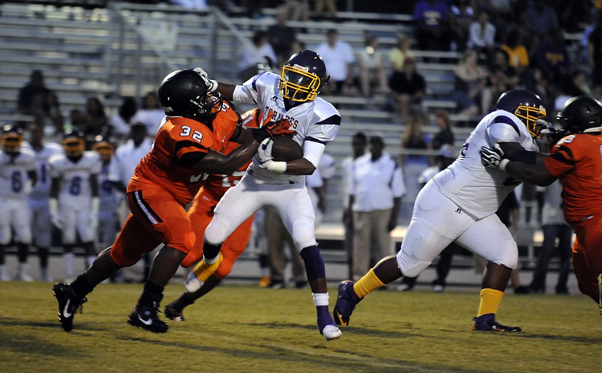 Sarasota linebacker David Anderson wraps up Booker running back Spencer Carter in the first half.