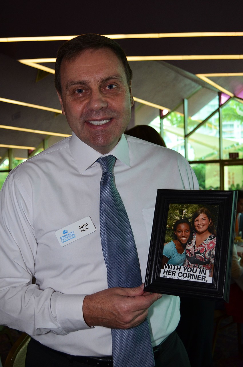 John Annis poses with a photo of his niece Gabrielle Holt, a student in Girls Inc. progams, that was at a table.
