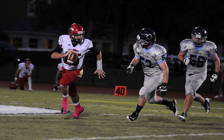 Cardinal Mooney quarterback Reese Vita scrambles for yardage in the first quarter.