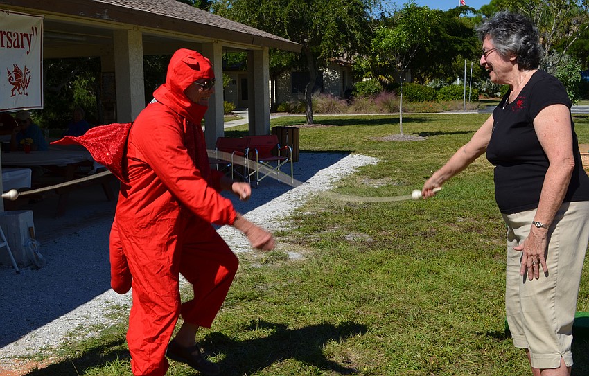 Bob Ferrell, dressed as the Welsh dragon, attempts to jump rope while Amy Ferrell hold the rope.