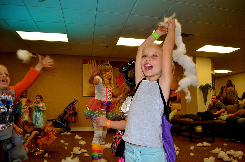 Allie May throws faux snow, or cotton, in one of the children's play areas.