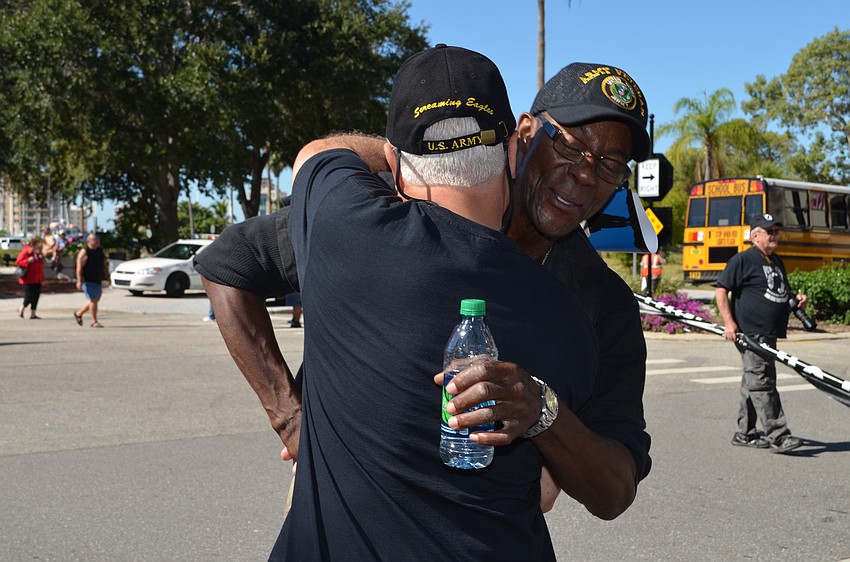 Friends Gary Barrack and Anthony J. embrace.