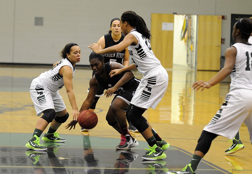 Braden Riverâ€™s Desha Parker attempts to drive past a pair of Lakewood Ranch defenders.