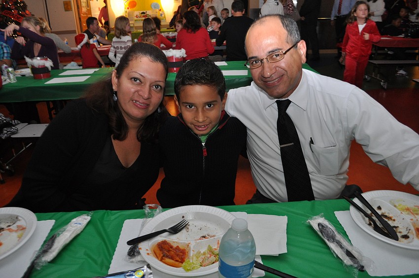 Mabel, Kenneth and Freddy Ordonez eat dinner before Kenneth performs on the drums.