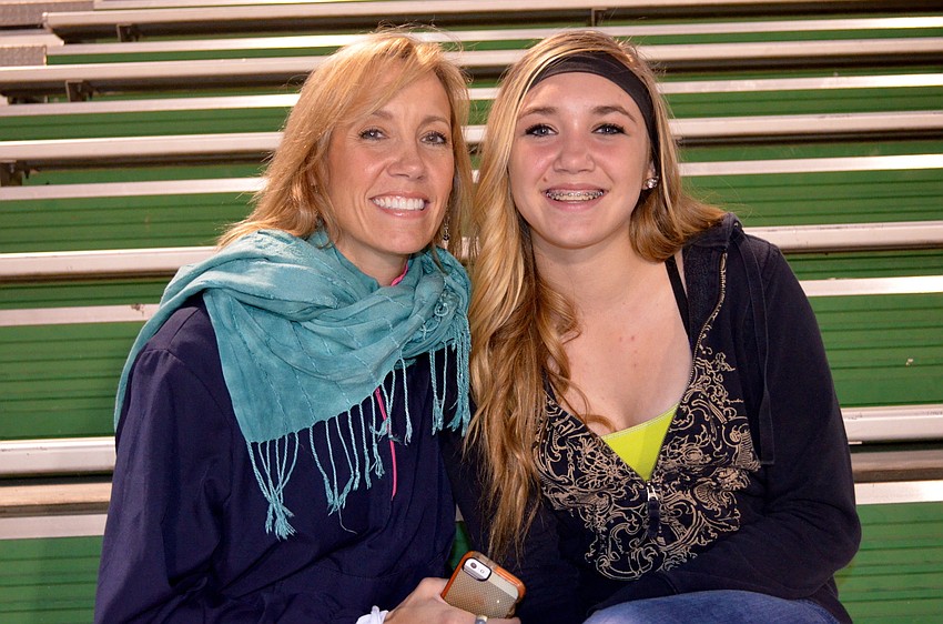 Maradith Meyer and her daughter, Peyton, cheer for the female football stars.