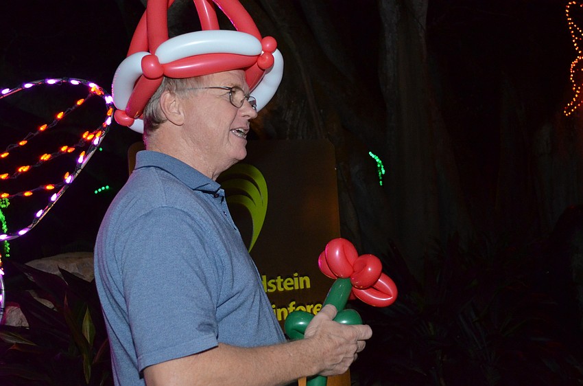 Greg Art creates a balloon hibiscus for a guest at Lights in Bloom.