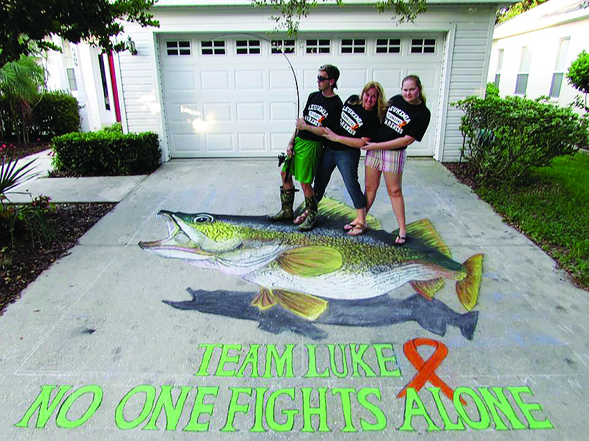 Nigel, Michelle and Ava Clinton, of Lakewood Ranch, reel in a walleye for their relative. Michelle created it with sidewalk chalk to encourage her nephew, Luke Schmillen, who has been battling leukemia at the Mayo Clinic in Minnesota.