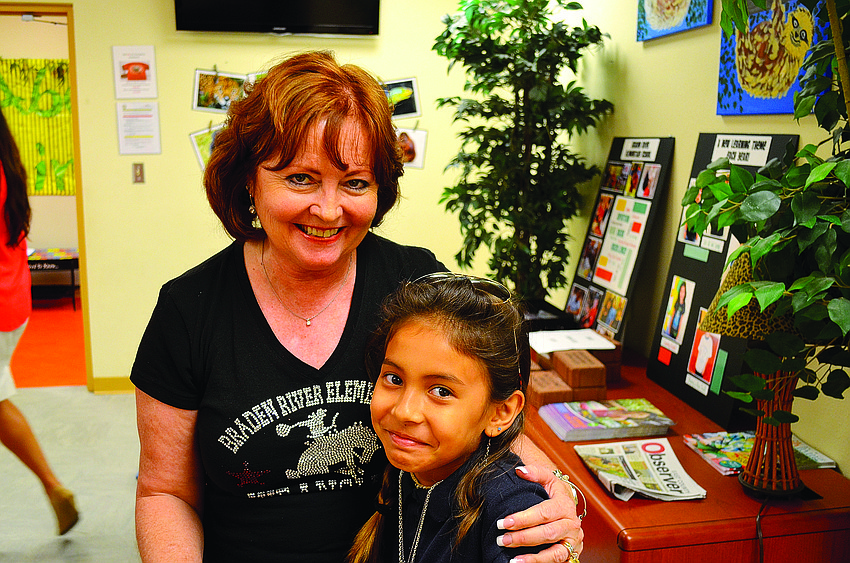 Longtime receptionist Kathy Keebler says goodbye to students, such as Kadence Baker, on her last day at Braden River Elementary.