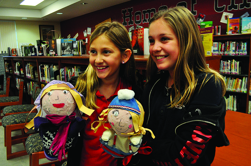 Caroline Pope and Zoe Polivchak display their Russian villager puppets at a Braden River Elementary show.