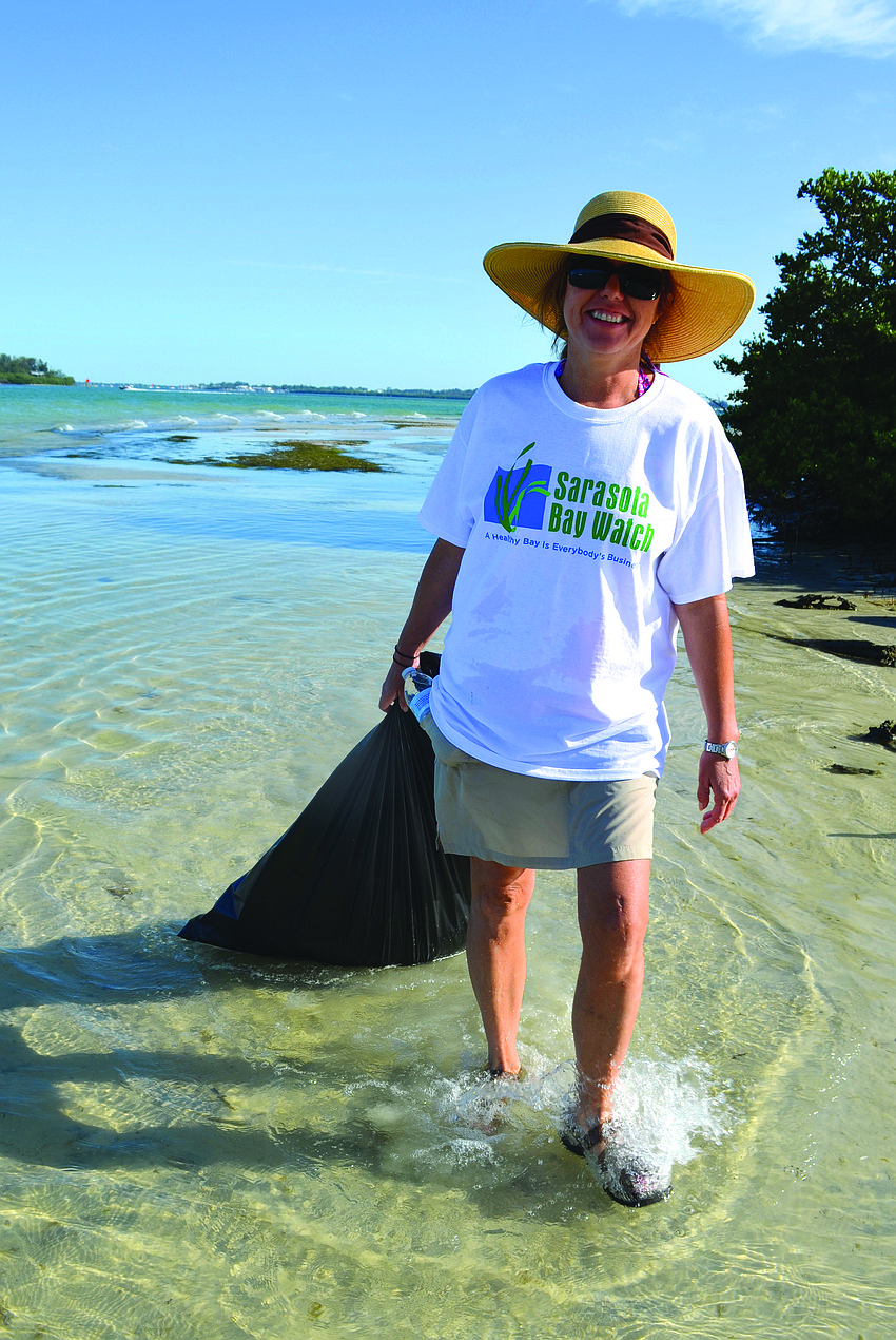 Volunteer Wanda Raible carries her first bag of trash to the main beach during Sarasota Bay Watch's sixth annual Sister Keys Cleanup May 17.
