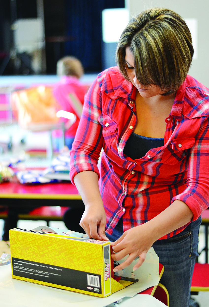 Josie Ludrigue, with the Sarasota Young Professionals, helps wraps gifts at Girls Inc. for Project Santaâ€™s Helpers.