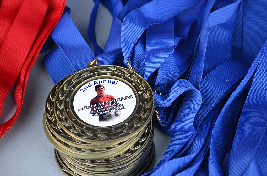 Medals for participants feature Andrew Monroe.