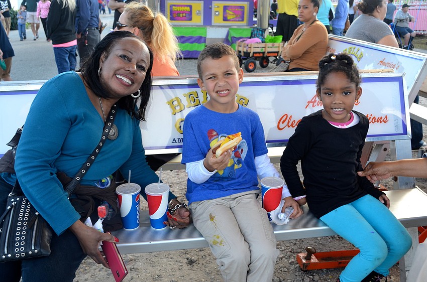 Cynthia Jolliff-Johnson, Landon Larkins and Kennedy Johnson enjoy snacks in the shade.