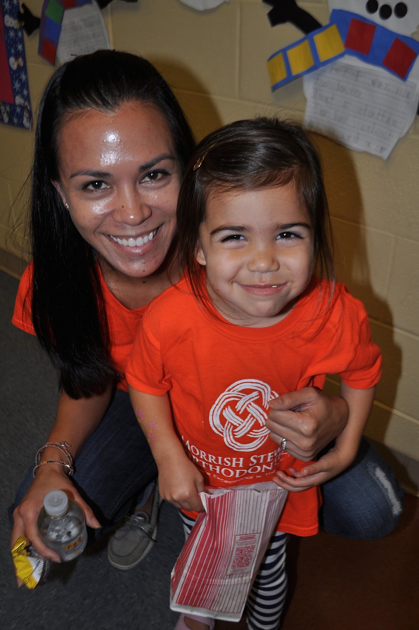 Jolene and Emery Stewart watch Emery's sisters, Isla and Avery, play Pringle bowling.