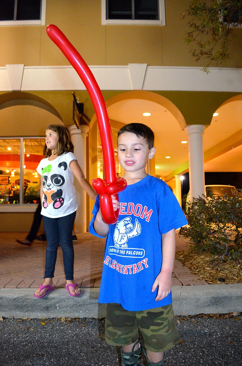 Five-year-old Brennan Perra admires his new balloon sword.