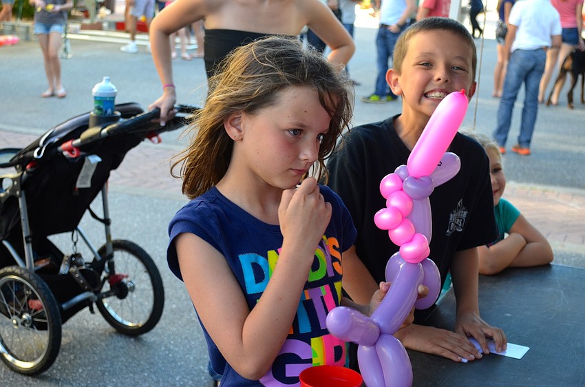 Clara and Devin Brown wait for their balloon creations.